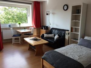 - une chambre avec un lit, un canapé et une table dans l'établissement Ferienwohnung "Krabbe", à Bremerhaven