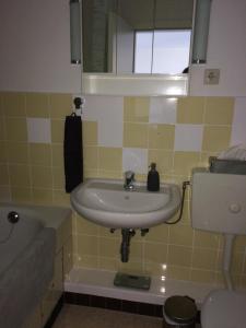 La salle de bains est pourvue d'un lavabo, d'une baignoire et de toilettes. dans l'établissement Ferienwohnung "Krabbe", à Bremerhaven