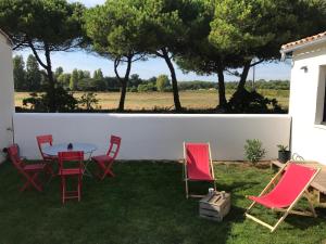 アル・アン・レにあるFleur de pin Ars en Réのパティオ(赤い椅子、芝生のテーブル付)