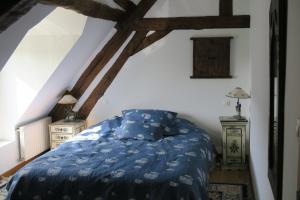 - une chambre avec un lit et une couette bleue dans l'établissement Mongrenon, à Escrignelles