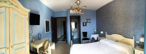 a bedroom with blue walls and a bed and a chandelier at Hotel Scilla in Scilla