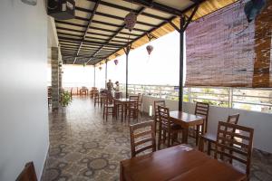 a restaurant with wooden tables and chairs and windows at Phu Hong Hotel in Phú Quốc