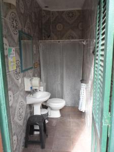 a small bathroom with a toilet and a sink at Freedom Hostel in Rosario