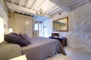 a bedroom with a bed and a mirror on the wall at THE RETREAT a romantic bedroom in Maremma in Cana