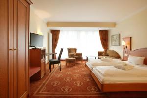 a hotel room with two beds and a television at Hotel Ochsen in Höfen an der Enz