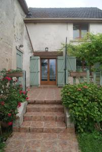 an entry to a house with a door and flowers at Maison d'Hôtes Ferme d'Issonges B&B in Marigny-en-Orxois