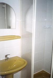 a bathroom with a yellow sink and a shower at KEREKERDO Vendeghazak in Hárskút