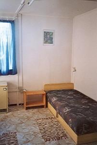 um pequeno quarto com uma cama e uma janela em KEREKERDO Vendeghazak em Hárskút