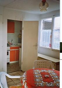 uma cozinha com uma mesa e uma cozinha com armários laranja em KEREKERDO Vendeghazak em Hárskút