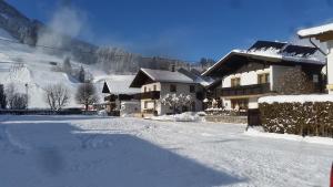 una calle cubierta de nieve frente a una casa en Haus Sonnheim, en Kirchberg in Tirol