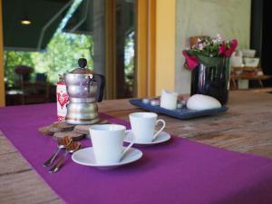 einen Tisch mit zwei Tassen auf einer lila Serviette in der Unterkunft Il giuggiolo in Conegliano