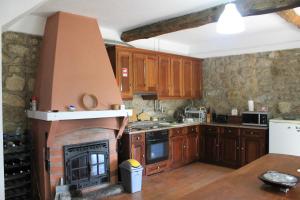 a kitchen with a fireplace in the middle of it at Casa do Batista in Britiande