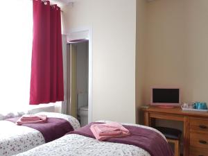 a bedroom with two beds and a television at ALARA Bed and Breakfast in Sheffield