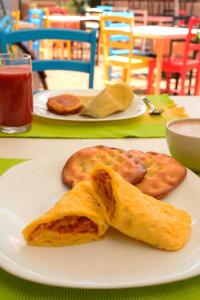 a white plate with some food on a table at Plaza Medina Hotel in Sáchica