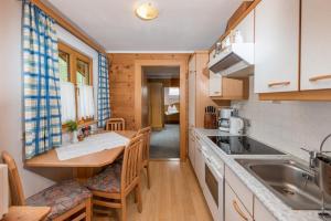 a kitchen with a table and chairs in a room at Landhaus Bergzeit in Filzmoos