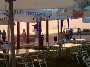 a group of tables and chairs with umbrellas on the beach at El Campanario in Chiclana de la Frontera