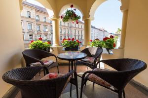 un balcón con mesas, sillas y flores en Vila Mărioara, en Sibiu
