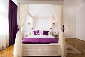 1 dormitorio con 1 cama con sábanas y cortinas moradas en Vila Mărioara en Sibiu