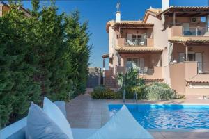 a villa with a swimming pool in front of a building at Aegina Villa Kalliopi in Egina