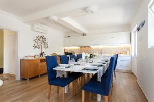 un comedor con una mesa larga y sillas azules en Villa Branca do Castelo, en Sesimbra