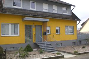 ein gelbes Haus mit gelber Vordertür in der Unterkunft Ferienhaus am Geiersberg in Walkenried