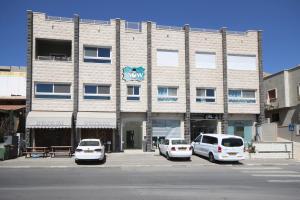 two cars parked in a parking lot in front of a building at סנו נופש בגולן in Majdal Shams