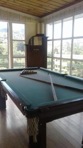 a green pool table in a room with windows at Casa Green Vista in Campos do Jordão