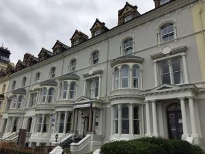 a large white building with many windows at Kensington Hotel in Llandudno