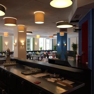 a bar in a restaurant with tables and chairs at Hotel Continental in Nuremberg