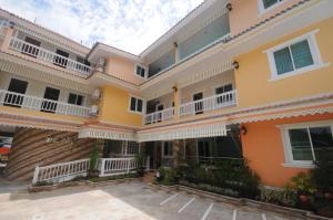 - un grand bâtiment avec des balcons blancs et orange dans l'établissement Chinathip Yusabuy, à Nan