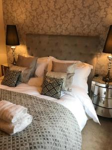 a bedroom with a bed with white sheets and pillows at Millwalk Apartment in Witney