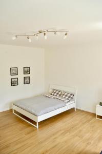 a white bedroom with a bed and a wooden floor at Stadtzentrum Mariazell in Mariazell