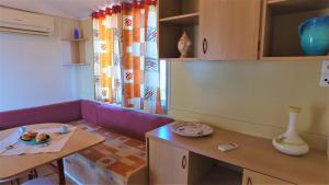 卡塔尼亞的住宿－露營愛奧尼亞酒店，客厅配有紫色沙发和桌子