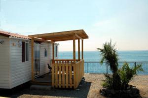 a house with a porch with the ocean in the background at Camping Jonio in Catania