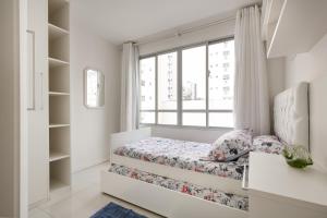 een kleine slaapkamer met een bed en een raam bij Apto 2 quartos, 1 quadra do Mar/Shop. Atlantico in Balneário Camboriú