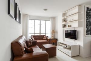 sala de estar con sofá y TV en Apto 2 quartos, 1 quadra do Mar/Shop. Atlantico en Balneario Camboriú