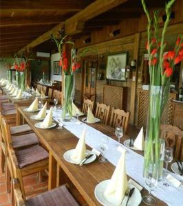 una mesa larga con sillas y jarrones con flores. en Ekoetno Selo Strug, en Krapje