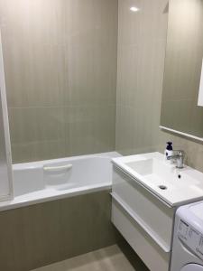 a white bathroom with a sink and a bath tub at Apartment Doma in Međugorje