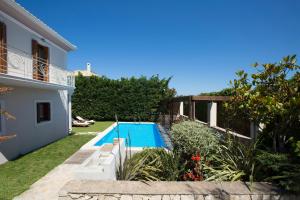 una piscina en un patio junto a una casa en Aeriko Homes of Distinction en Lefkada