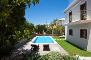 a swimming pool in a yard next to a house at Aeriko Homes of Distinction in Lefkada