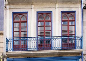 a building with three windows and a balcony at Aliados Town Hall in Porto