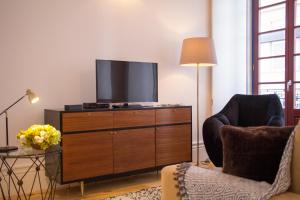 a living room with a television on a dresser at Aliados Town Hall in Porto