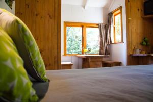 a bedroom with a bed with a green pillow on it at Hush Boutique Accommodation in Coromandel Town