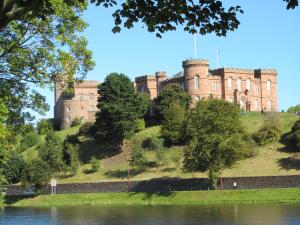 a castle on a hill next to a body of water at Bridge Street Apartments in Inverness