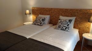 a bedroom with two beds with white sheets and pillows at Route 2 Torrão in Torrão