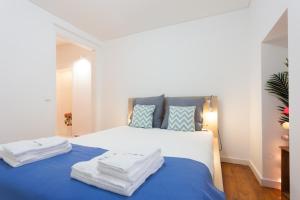 um quarto com uma cama com duas toalhas em FLH Príncipe Real Comfortable Flat em Lisboa