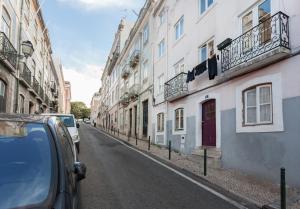 ulica z samochodami zaparkowanymi po stronie budynku w obiekcie FLH Príncipe Real Comfortable Flat w Lizbonie