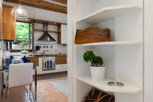 uma cozinha com paredes brancas e armários de madeira em CA' DIVA em Veneza