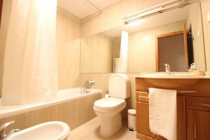 a bathroom with a toilet and a sink and a bath tub at Agudela Vista Mar in Lavra +13 photos