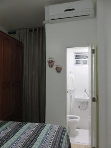 a bedroom with a bed and a bathroom with a toilet at Seu Lugar Em Copacabana in Rio de Janeiro